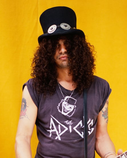 Slash with his trademark top hat jammed down over very curly dark hair which covers most of his face