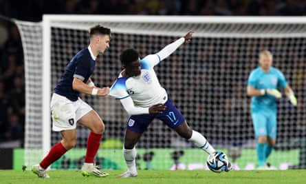 Bukayo Saka of England is challenged by Kieran Tierney of Scotland during the 150th Anniversary Heritage Match.