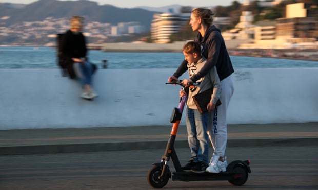 A woman and child on an e-scooter by the Black Sea.