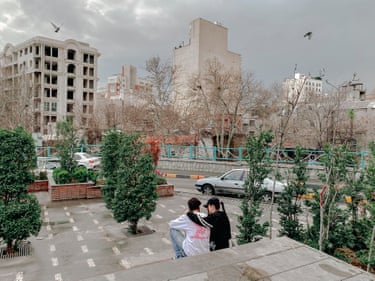 Two young people sit on a terrace in an otherwise deserted part of town