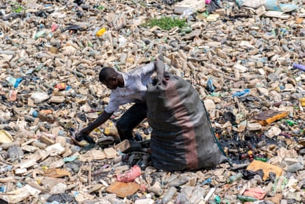 A man recovers recyclable plastic waste near the Korle Lagoon in Accra