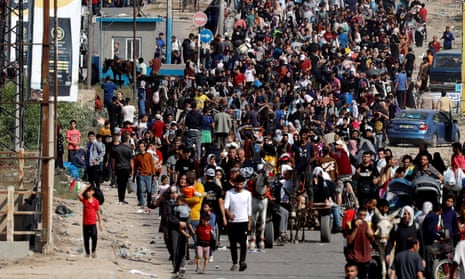 Palestinians fleeing the northern Gaza Strip walk southward through central Gaza on Thursday