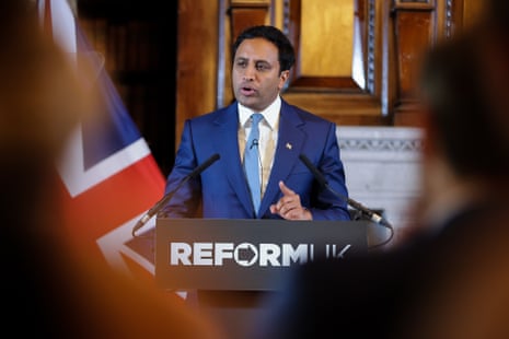 Zia Yusuf speaking at a podium during a Reform UK press conference.