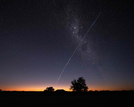 A long-exposure image of nan Milky Way pinch silhouettes of trees visible supra sky line