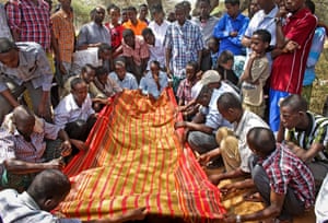 Mourners gather at the grave of radio producer Abdihared Osman Aden, who was shot while walking to work in 2013