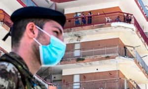 An Italian soldier standing guard below buildings inside the red zone where 49 cases of coronavirus infections were confirmed in Mondragone, Southern Italy.