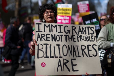 A person carries a placard as demonstrators gather prior to the march against far-right in Park Lane.