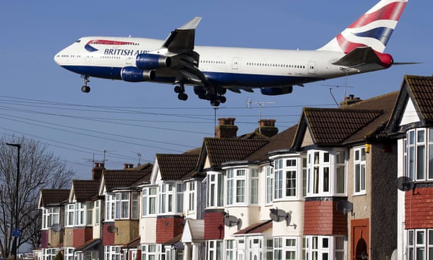 A British Airways Boeing 747   flies very low over houses as it prepares to land