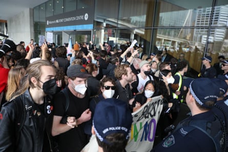 Se exhiben calcomanías de 'El socialismo apesta' mientras CPAC Australia aviva los temores de la voz indígena 2 Protestas contra CPAC fuera del Centro Internacional de Convenciones en Sydney.