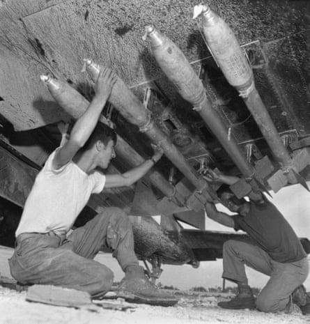 US Marines load five-inch rockets under the wing of a Corsair fighter during Battle of Okinawa