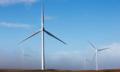 wind turbines against a blue sky with wispy clouds