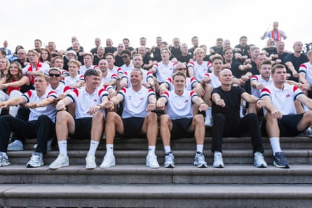 Norway’s men’s football team sits on stone steps with supporters, fists clenched