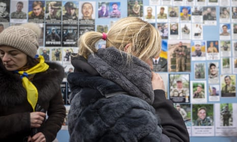 Ukrainians visit St Michael's Golden-Domed Monastery in Kyiv, where photographs of soldiers who lost their lives are displayed wall on the first anniversary of the Russian invasion. 