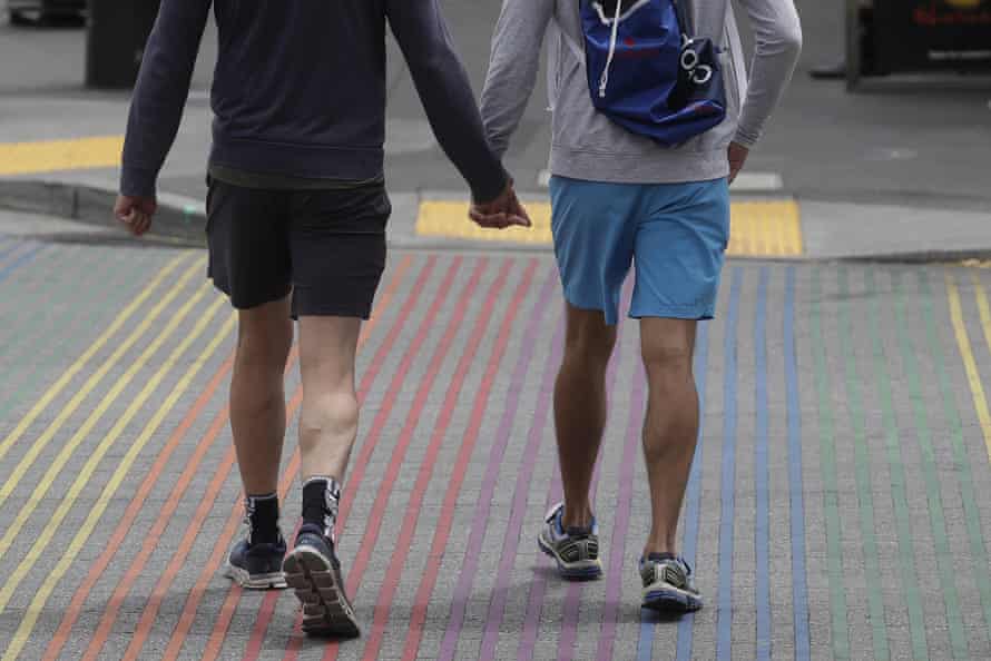 men walk on a rainbow colored sidewalk