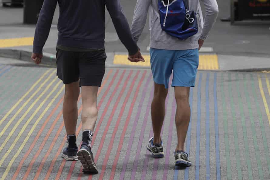 men walk on rainbow-colored pavement