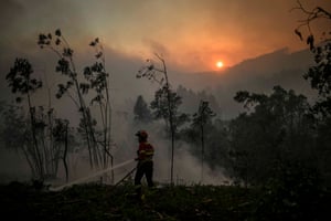 A firefighter tackles a wildfire at the village of Asseiceira Pequena in Mafra