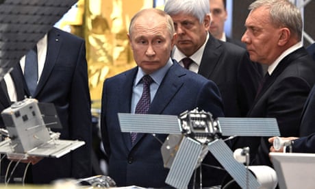 Vladimir Putin observing models of satellites at a Russian spacecraft manufacturer's headquarters.