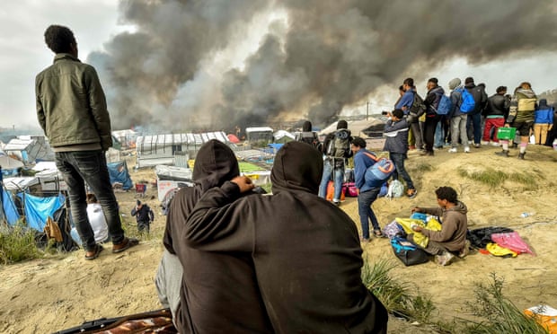 Children watch Calais refugee camp burn
