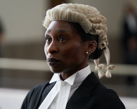 woman wearing black and white in barrister wig looks ahead in courtroom