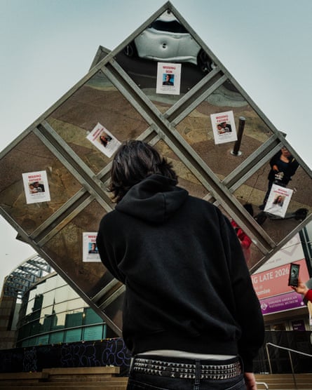 A young man in downtown Los Angeles looks at missing signs of people arrested and deported by ICE