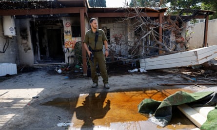 Lt Col Yaron Buskila stands in front of a wrecked building