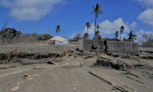 ash covered and flattened buildings in Tonga