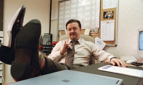 Ricky Gervais, his feet up on a desk, as David Brent in The Office.