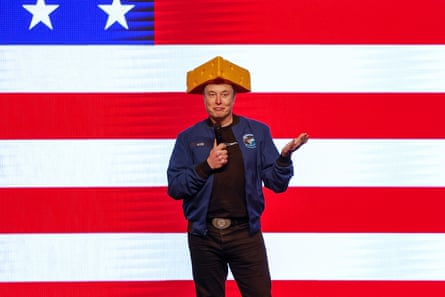a man in a cheesehead hat in front of a giant us flag