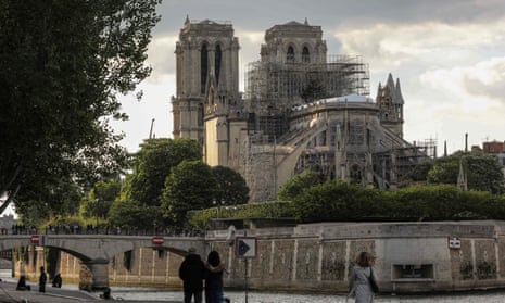 Pedestrians walking towards Notre Dame cathedral in Paris.