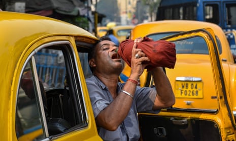 A taxi driver is seen drinking water from a bottle during afternoon heat in Kolkata as a heatwave grips Asia 