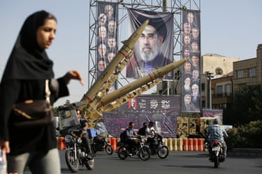 Motorcyclists ride past missiles, air defence systems and unmanned aerial vehicles