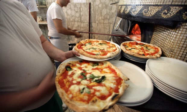 Cooks making pizzas in a restaurant