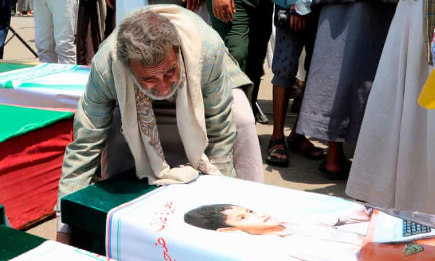 A Yemeni man mourns over a boy’s casket during a mass funeral on Monday.