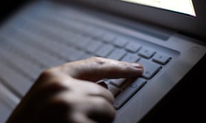 A person's finger pressing the delete button on a laptop