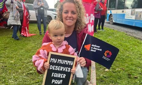 Amy Corry and her daughter Penny with sign saying My mummy deserves better pay