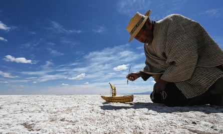 Felix Mauricio, a member of the Uru Murato Indigenous community, puts a miniature replica of a boat known as a “totora boat” on a desert at the site of former Lake Poopo, near the village of Punaca Tinta Maria, province of Oruro, Bolivia.