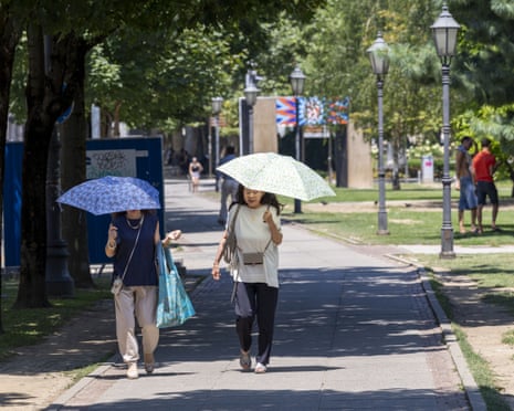 People shelter from the sun with umbrellas during sunny and hot weather as heatwave affecting Europe reaches Zagreb, Croatia.