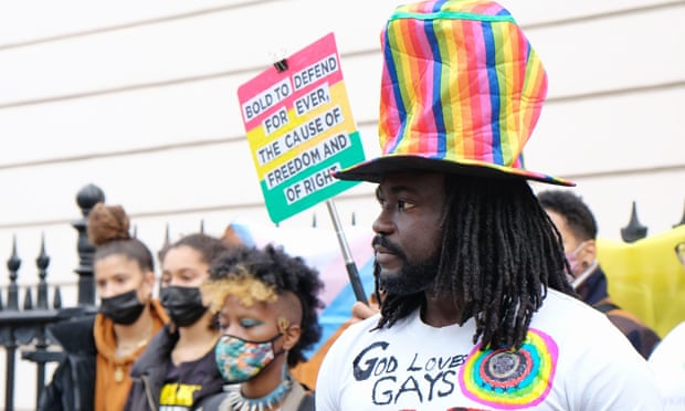 London, UK. Activists gather to protest against Ghana's sweeping anti-gay law currently being debated in the country's parliament. A man wears a rainbow hat with a t-shirt that says
