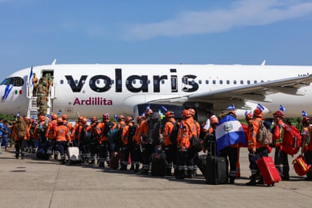 Queue of people, many in hi-vis, board a plane with Volaris on the side