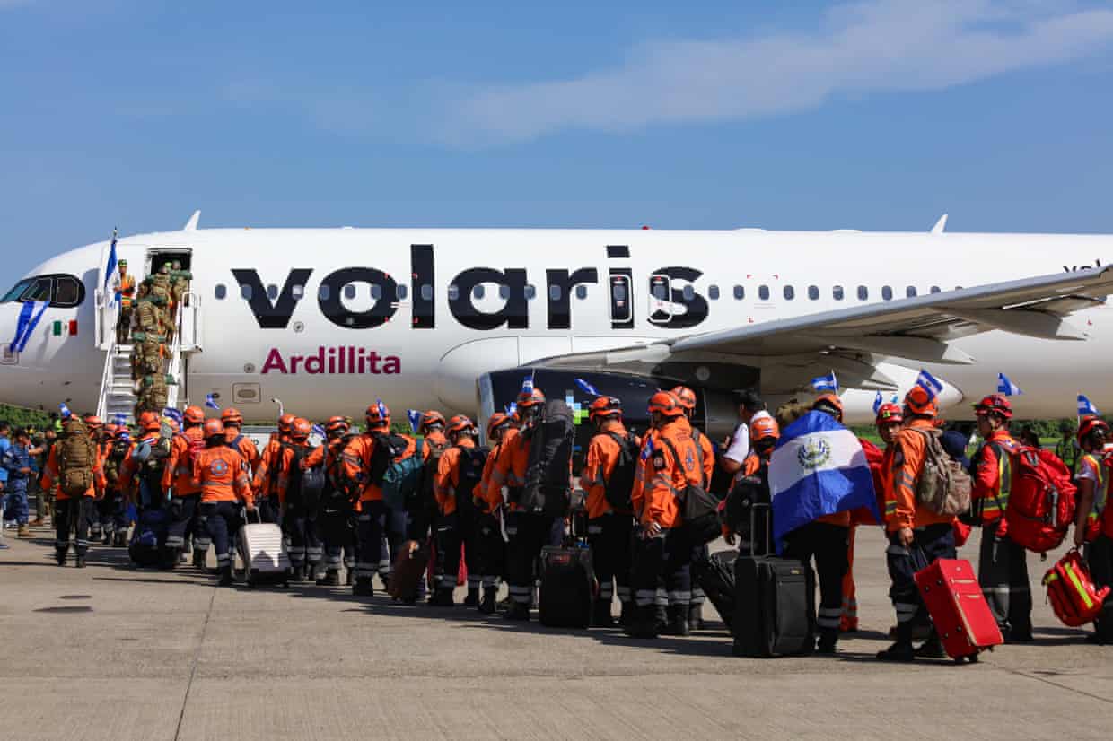 Queue of people, many in hi-vis, board a plane with Volaris on the side