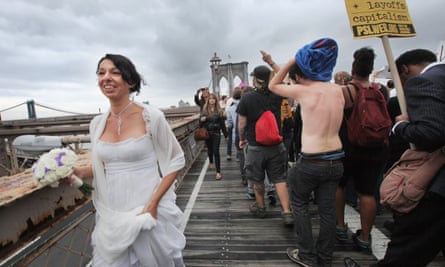A bride walks past Occupy protesters as they cross the Brooklyn Bridge on 1 October 2011.