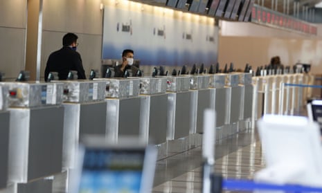 An agent adjusts his face mask while waiting for customers at a ticketing counter for American Airlines in the main terminal at Denver International Airport on Sunday 3 May, 2020.