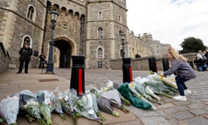 Children add to the floral tributes for Prince Philip outside the Henry VIII Gate of Windsor Castle.