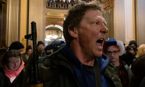 A protester yells at Michigan State Police after protesters occupied the state capitol building during a vote to approve the extension of governor Gretchen Whitmer’s stay-at-home order.
