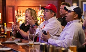 People applaud the announcement of an electoral vote for former US President and Republican Presidential candidate Donald Trump at an election watch party