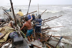 A Taroyo family living along the coast of Manila Bay search for salvageable items after their house was damaged by typhoon Koppu in October 2015.