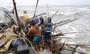 A family living along the coast of Manila Bay search for salvageable items after their house was destroyed by strong winds brought by typhoon Koppu on Sunday.
