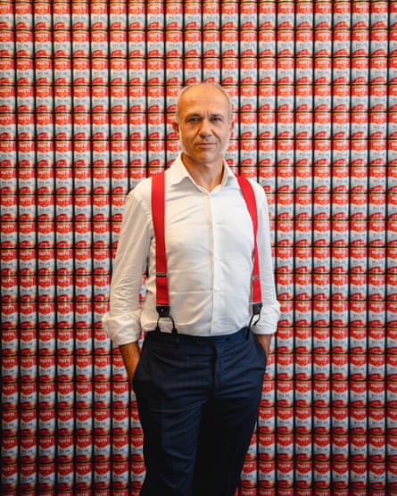 Francesco Mutti in front of a wall of Mutti tins