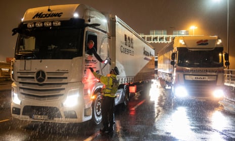 A police officer checks a lorry driver’s information as lorries and thousands more vans wait to cross the Channel. 