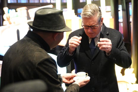 Starmer inspecting a tea cup at a market in Yuyuan Garden in Shanghai, China